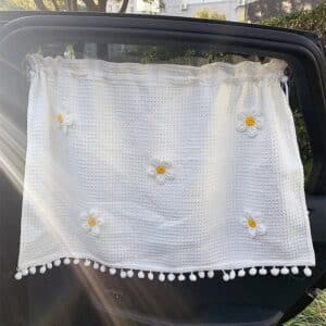 Pare-Soleil Voiture Blanc Décoré de Fleurs installé sur une fenêtre de voiture