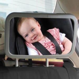 Miroir Voiture Bébé Confort Réglable et Adaptable installé sur l'appui-tête d'un siège arrière avec un bébé dans le reflet du miroir